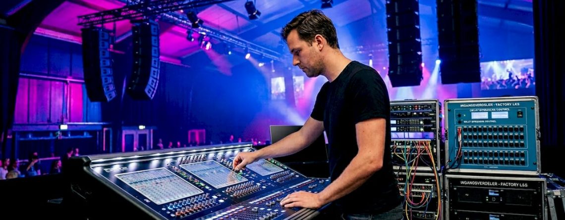 Een technicus stelt de geluidsvertraging van de luidsprekers in de zaal nauwkeurig af.