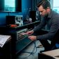 Man die bezig is om de kabels van zijn audiosysteem thuis aan te sluiten