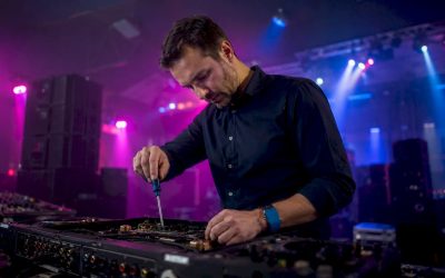 Een technicus controleert zorgvuldig een professionele audiomixer.