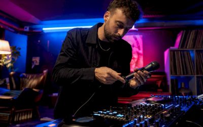 De DJ plugt zijn microfoon in op het mengpaneel.