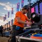 Een lichttechnicus hangt de verlichting op aan het podium van een festival.