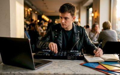 Een jonge man is thuis aan het draaien op zijn DJ-controller.