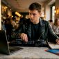 Een jonge man is thuis aan het draaien op zijn DJ-controller.