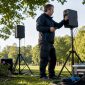 Een technicus voert buiten tests uit met speakers die bestand zijn tegen alle weersomstandigheden.