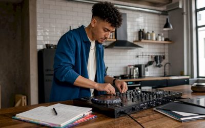 Een jonge man is thuis bezig met zijn dj-controller en draait muziek vanuit zijn eigen studiohoekje.