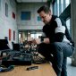 Een DJ is in zijn thuisstudio bezig met het netjes wegwerken en ordenen van alle kabels.