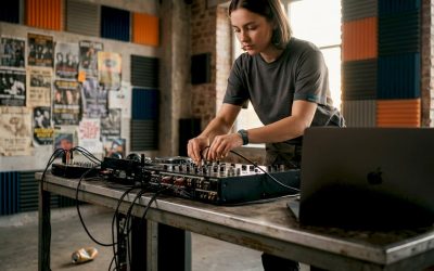 Een DJ is bezig met het aansluiten van kabels op zijn mengpaneel in zijn thuisstudio.
