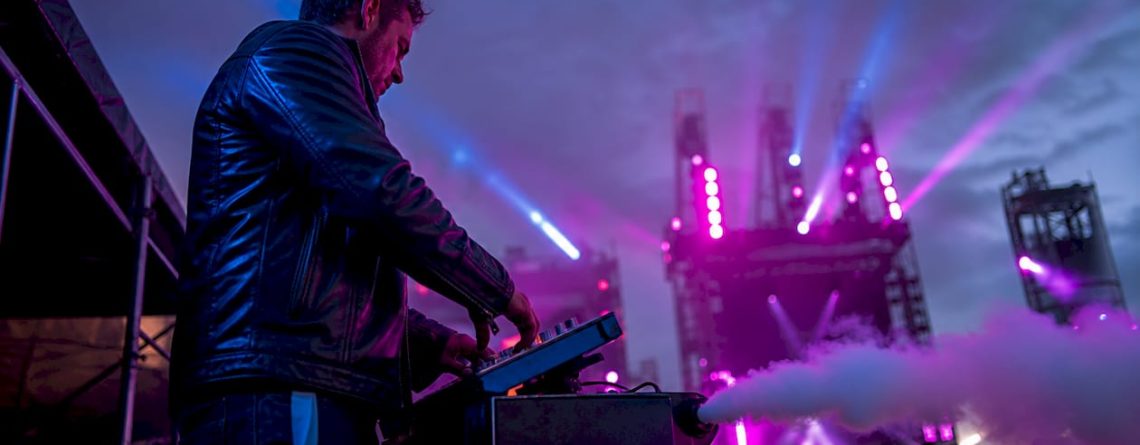 Een technicus bedient de rookmachine tijdens een concert op het podium.