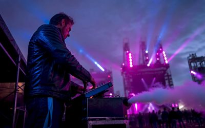 Een technicus bedient de rookmachine tijdens een concert op het podium.