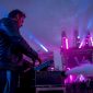 Een technicus bedient de rookmachine tijdens een concert op het podium.