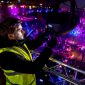 Een technicus is 's avonds tijdens een festival bezig om een LED-lamp af te stellen.