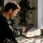 Man bekijkt verschillende alternatieven voor hppl.nl op zijn tablet