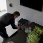 Man voorziet zijn woonkamer van een nieuw surround sound systeem