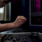 Een technicus plaatst een kooimoer in een 19-inch serverrek.