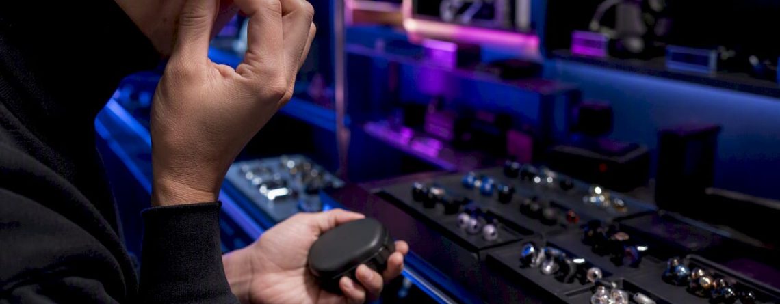 Een medewerker past een in-ear monitor aan in de showroom.