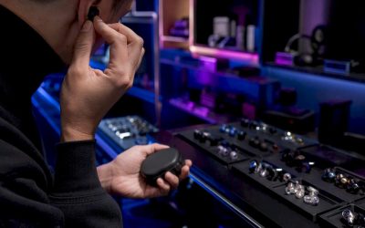 Een medewerker past een in-ear monitor aan in de showroom.