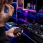 Een medewerker past een in-ear monitor aan in de showroom.