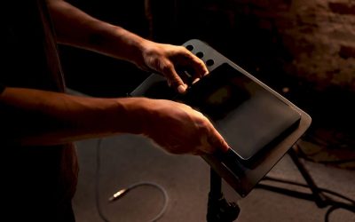 Een muzikant zet zijn tablet en voetpedaal klaar om de bladmuziek digitaal te kunnen lezen.