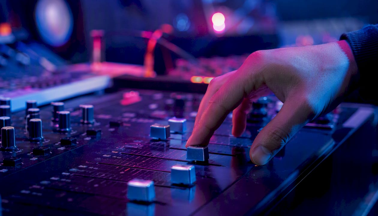 Detailopname van een DJ-mixer waarbij de fader actief wordt gebruikt