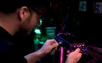 Een technicus sluit een ethernetkabel aan op een DMX-node.