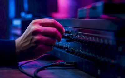 Een DJ draait aan de knoppen van de audiomixer om het geluid perfect af te stemmen.
