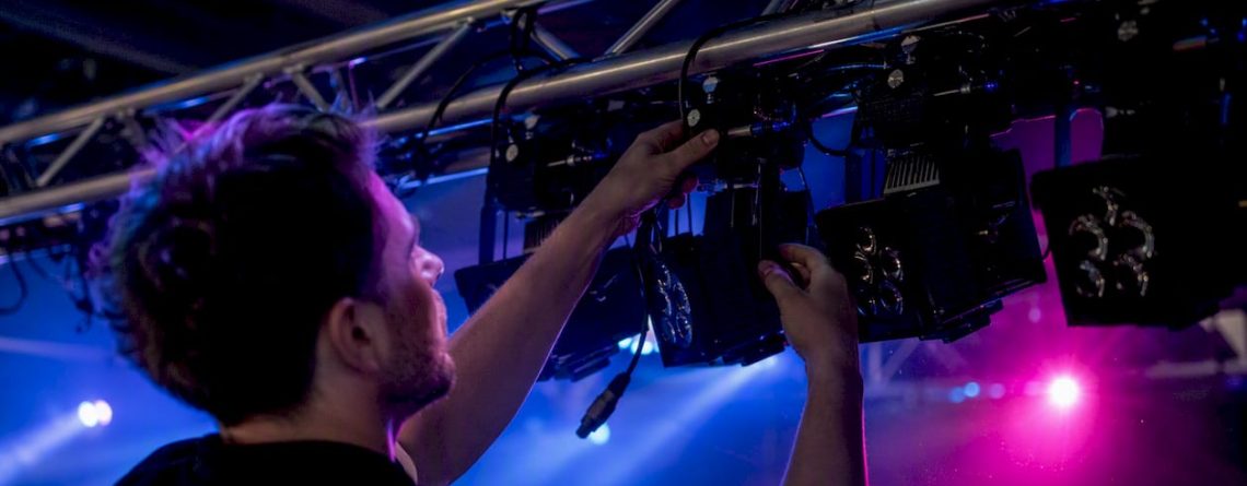 Handen die DMX-spotlights aan een truss bevestigen en groeperen