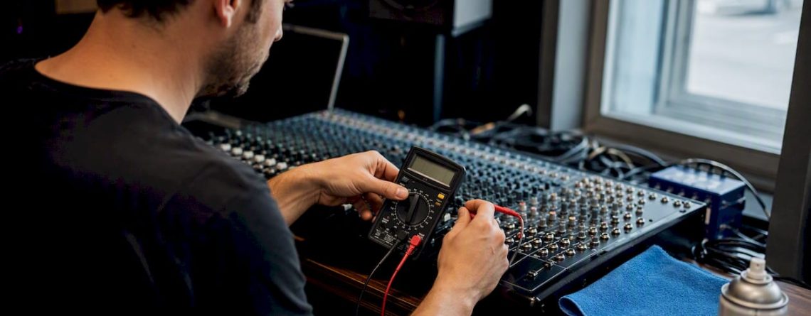 Iemand stelt een mengpaneel af in de studio