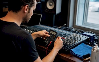 Iemand stelt een mengpaneel af in de studio