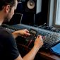 Iemand stelt een mengpaneel af in de studio