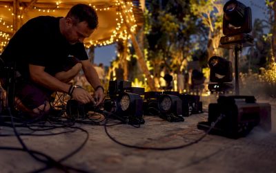 Een technicus is bezig met het installeren van uplights en bewegende spotlights.