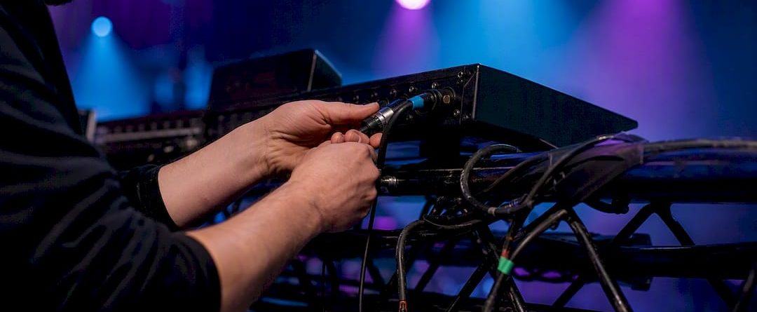Handen maken de verbinding van een DMX XLR-kabel met een lichtcontroller