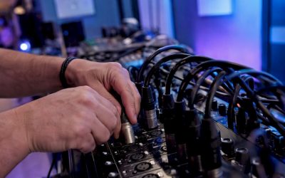 Handen die een gebalanceerde audiokabel aansluiten