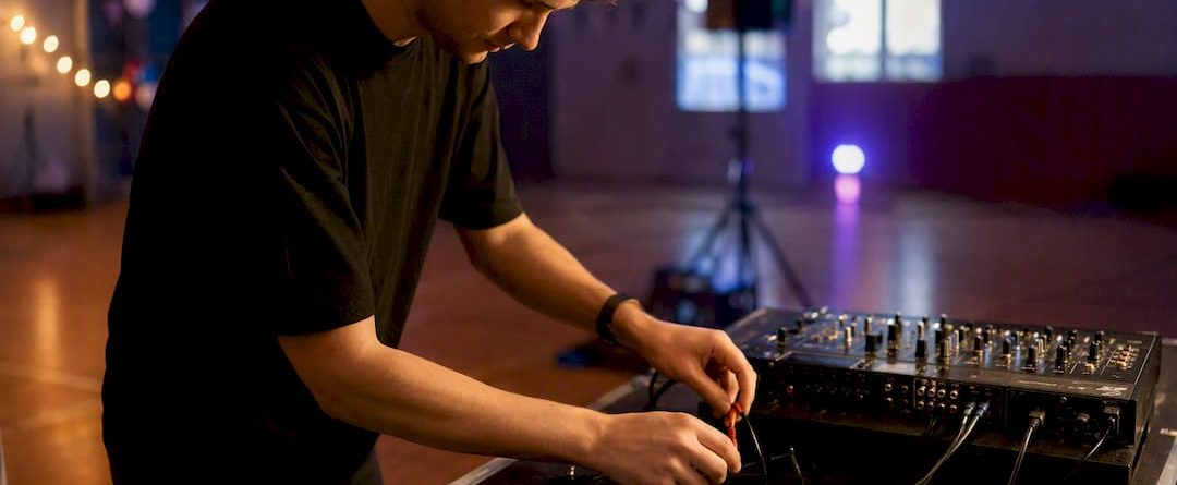 Handen die kabels aansluiten op een DJ-set