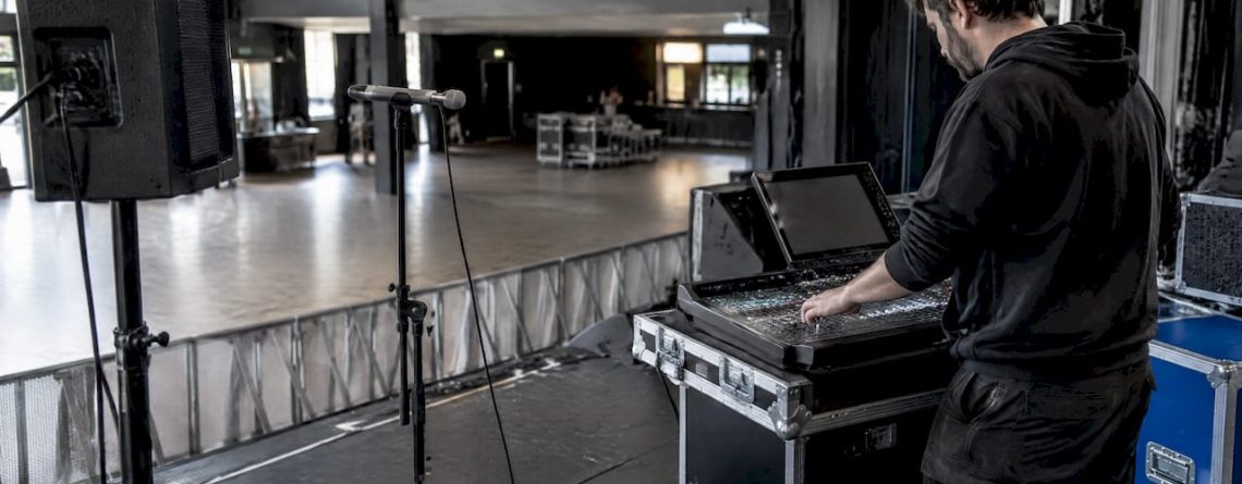 Technicus stelt het PA-systeem af met een meetmicrofoon