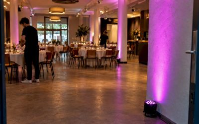 Uplighters kleuren de muren van een trouwzaal