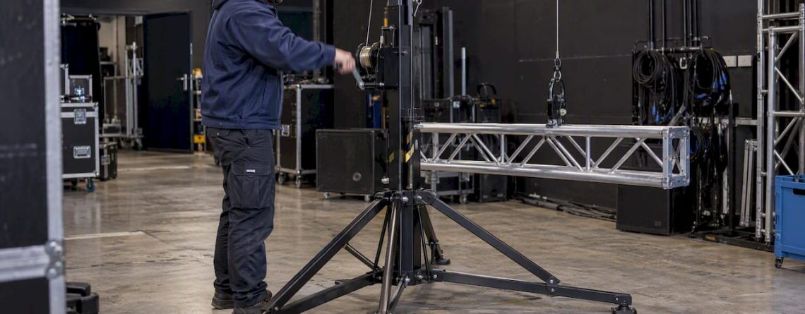 Technicus hijst truss met wind-up statief