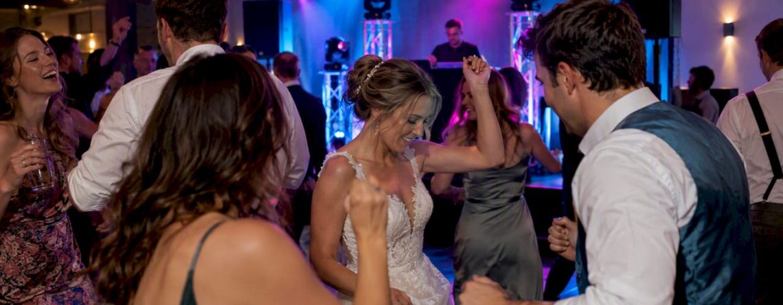 Gasten dansen onder de feestverlichting op een bruiloft