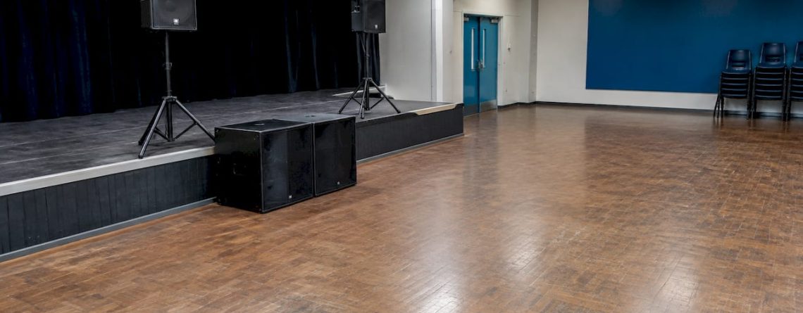 Subwoofers geplaatst vlakbij het podium van een evenementenhal