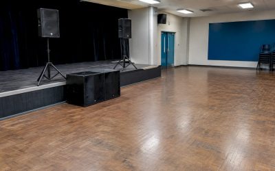 Subwoofers geplaatst vlakbij het podium van een evenementenhal